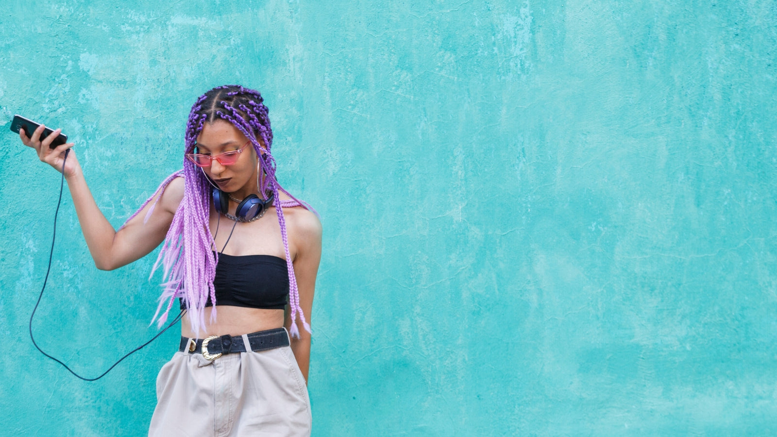 Trendy young lady in a crop top with purple braided hair